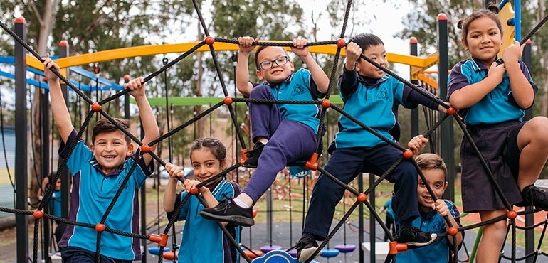 A group of young students play in a playground web. 